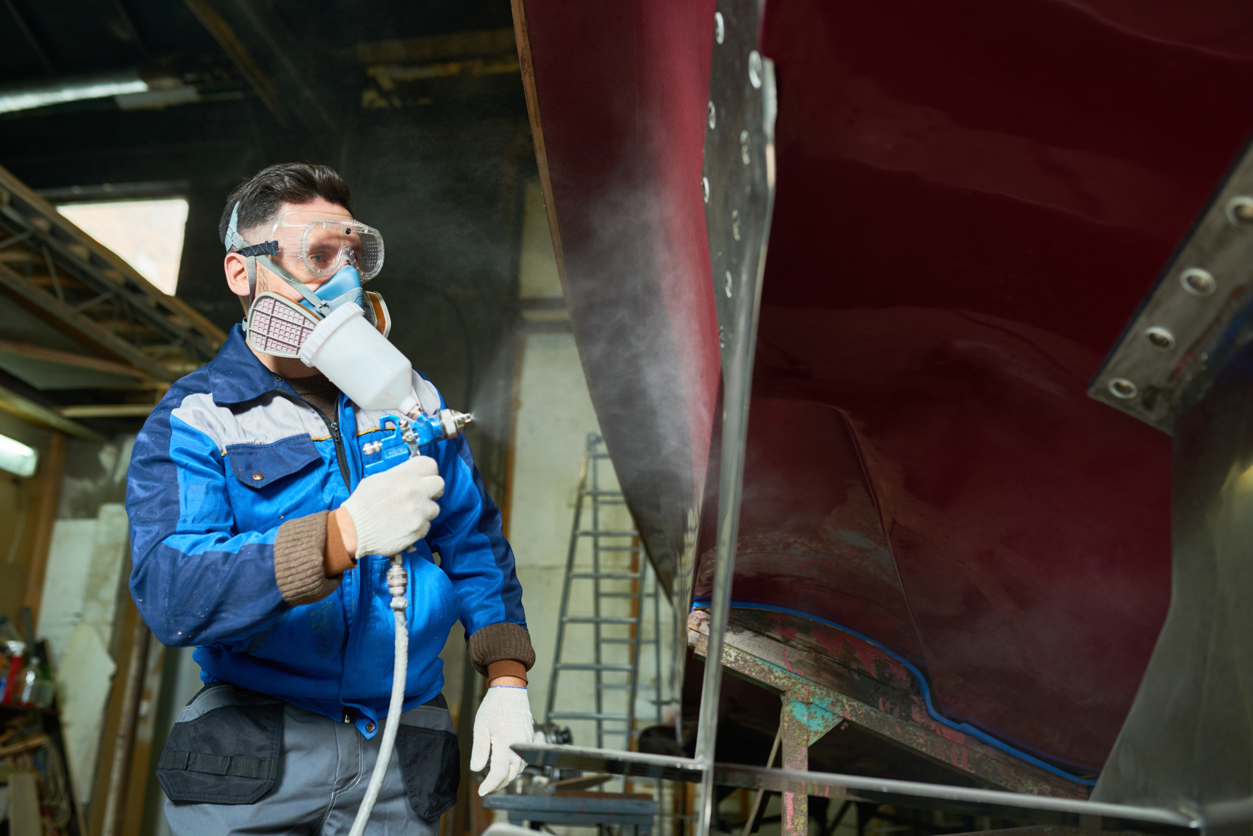 worker-painting-boats-yacht-workshop