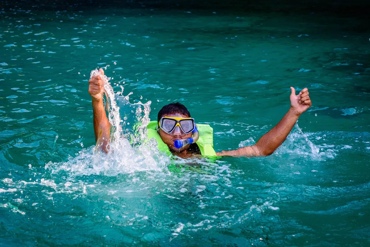 snorkeler giving the thumbs up from the water